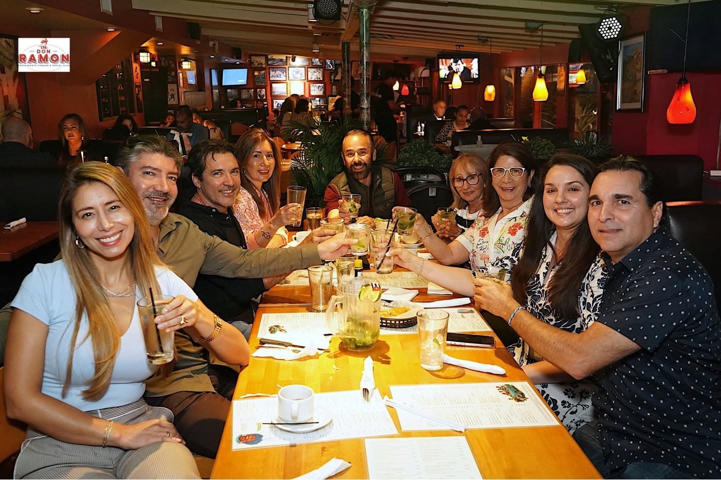 A table of friends raising mojitos in a toast in the Don Ramon dining room