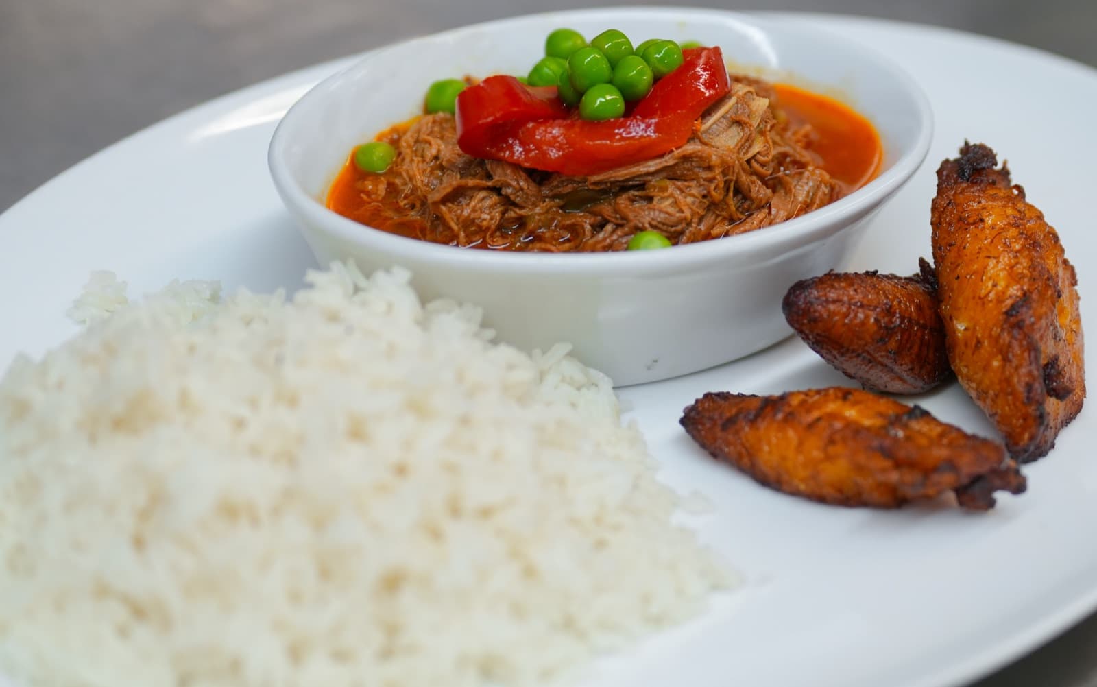 Ropa vieja plated with yellow rice and sweet plantains