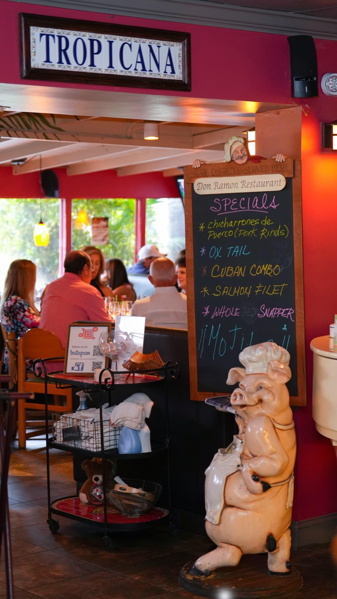 The daily specials board and the chef pig beneath the Tropicana sign